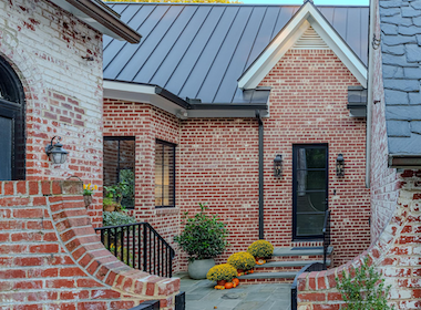 Modern brick home entrance with seasonal decorations and plants